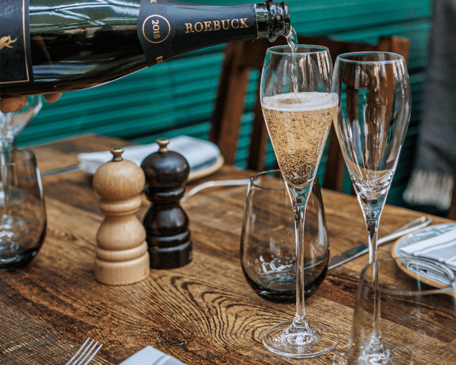 Roebuck sparkling wine being poured into a champagne flute.