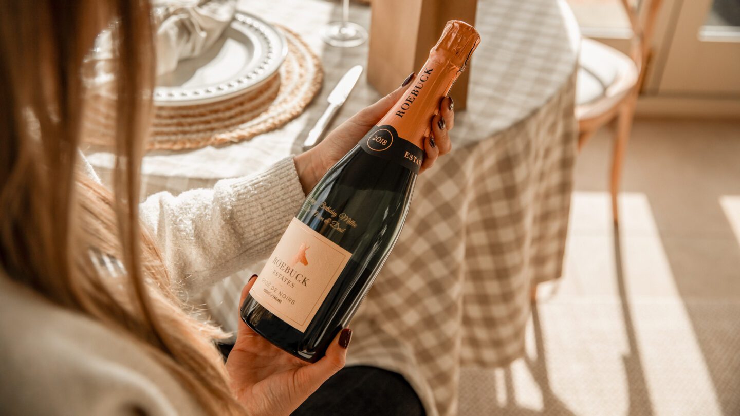 Hands holding personalised bottle of Roebuck Rose English Sparkling Wine