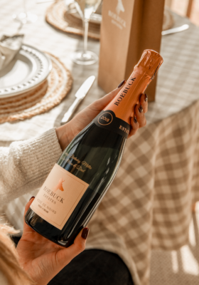 Woman holding a personalised bottle of Roebuck Rose De Noirs.