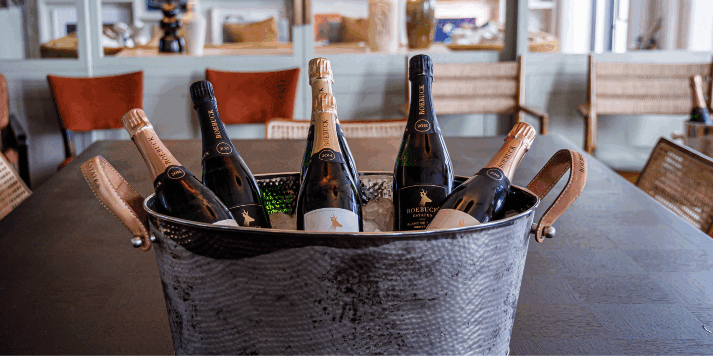 Wine Club Banner Image Selection of Roebuck Estates sparkling wines in large silver ice bucket in home